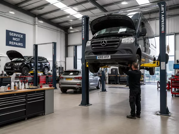 Clean, well-equipped UK vehicle repair centre with cars on hydraulic ramps